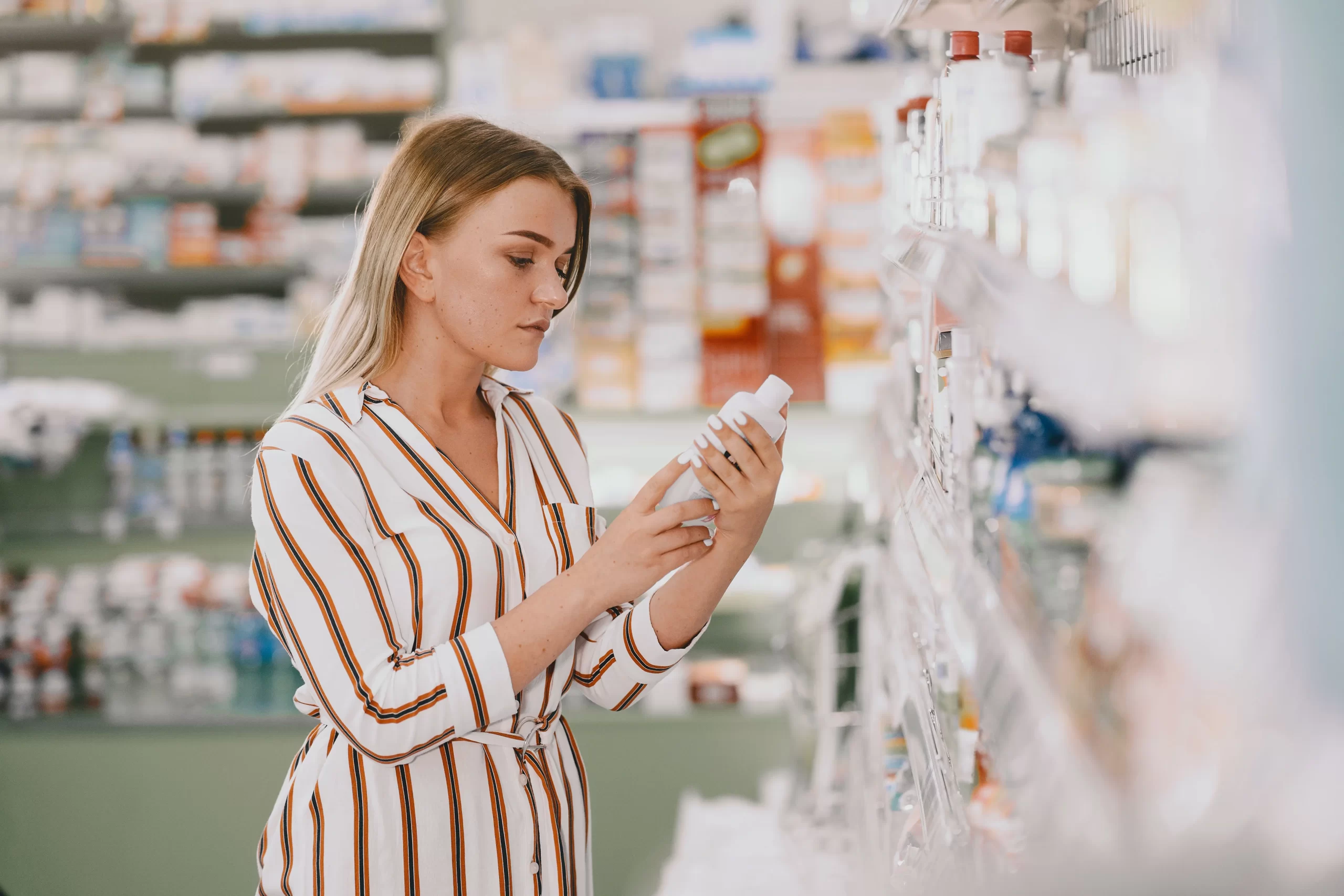 Mujer viendo surtido de farmacia.